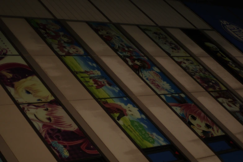 a tall building with many windows decorated in anime posters