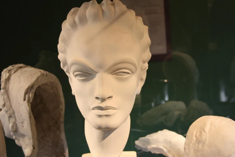 an artistic white plaster bust with a large rock