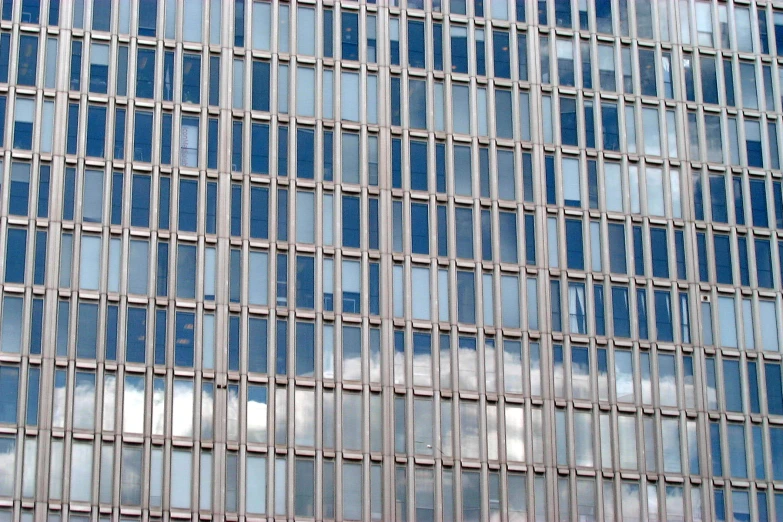 a tall skyscr with many windows that are reflecting sky