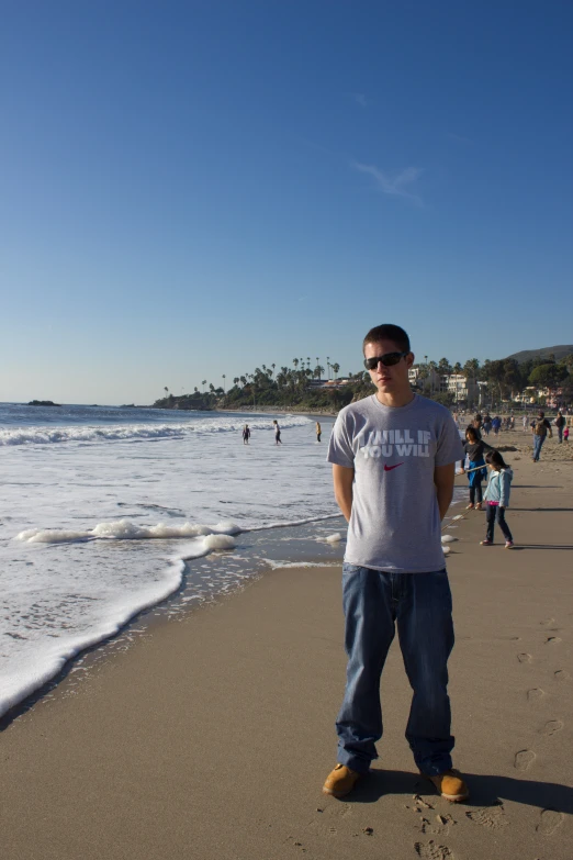 the man standing on the beach has his feet in the sand