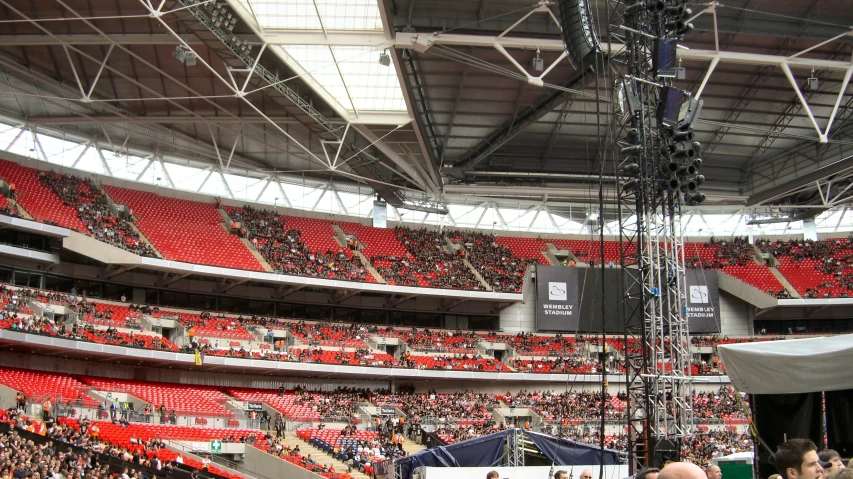 the crowd in a large stadium looks at the speaker on the podium