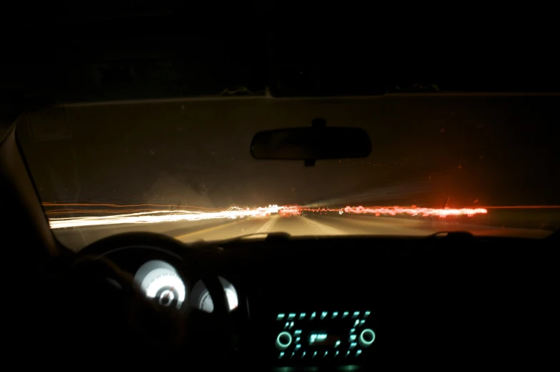 the dashboard light of a car is reflecting its lights in the windshield