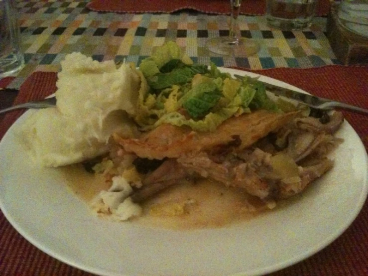 a plate topped with meat, mashed potatoes and vegetables