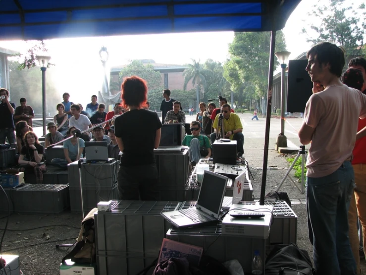 people in an outdoor music area with people sitting and standing