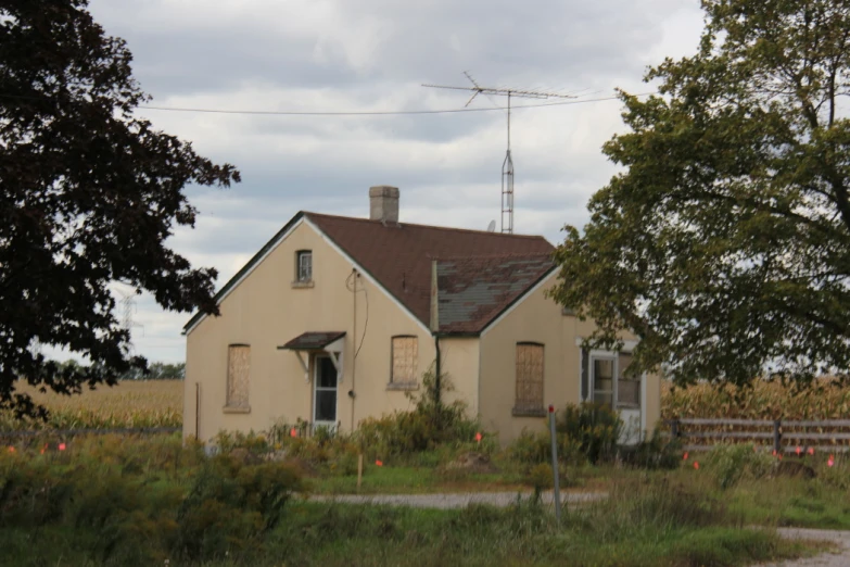 an old home sits in the middle of a field