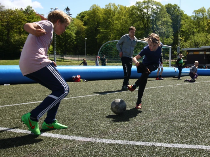 young people are on a soccer field playing soccer