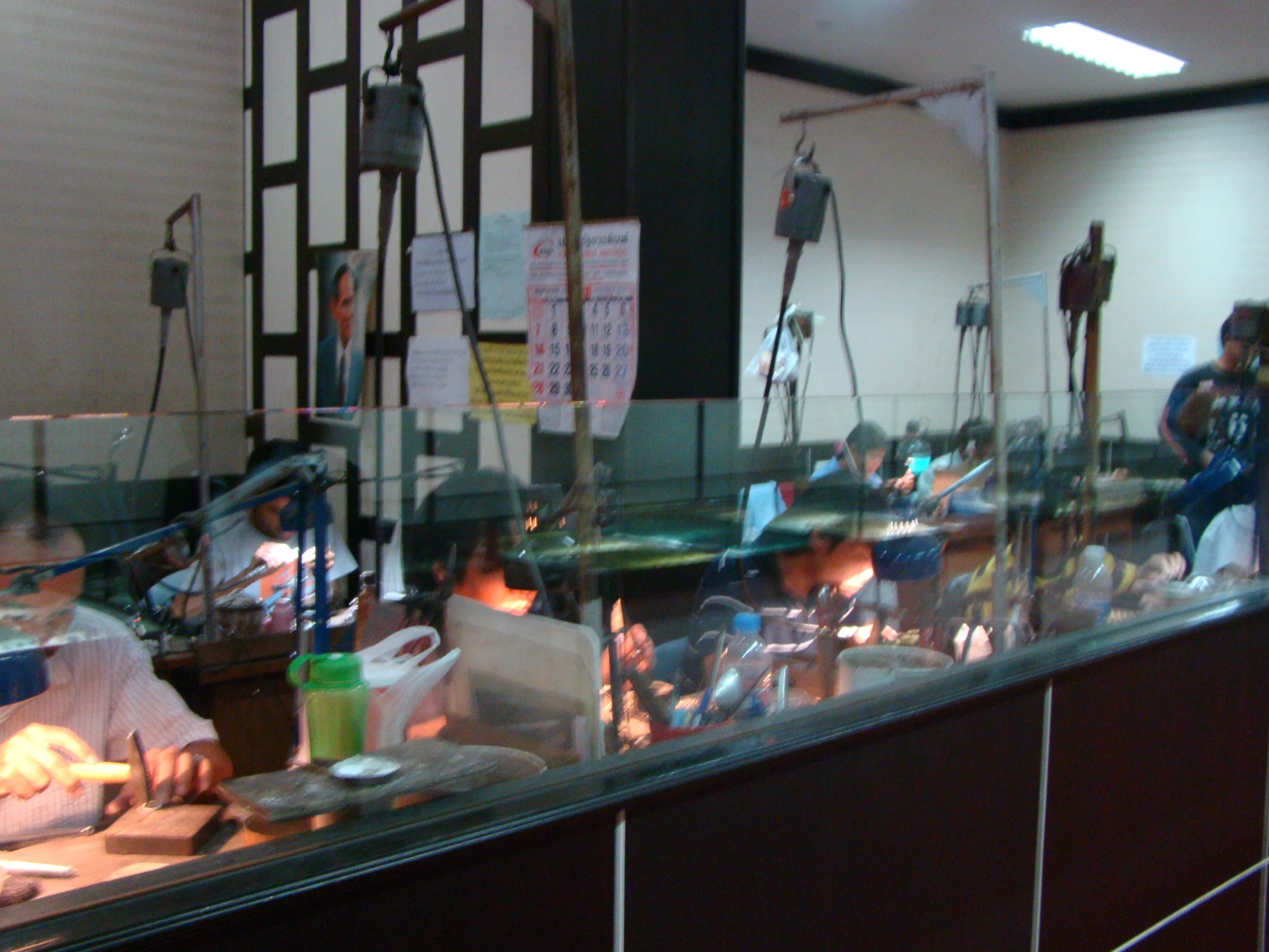 a group of people sit around a counter in a restaurant