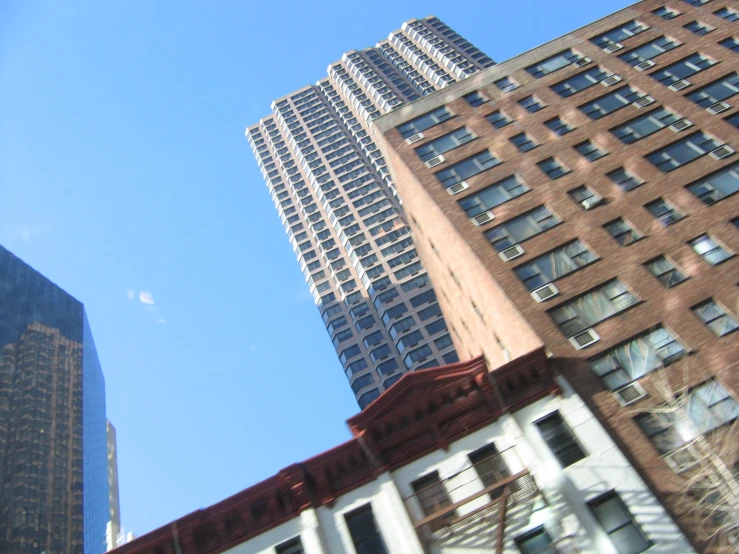 an intersection with a building and fire escapes against the blue sky