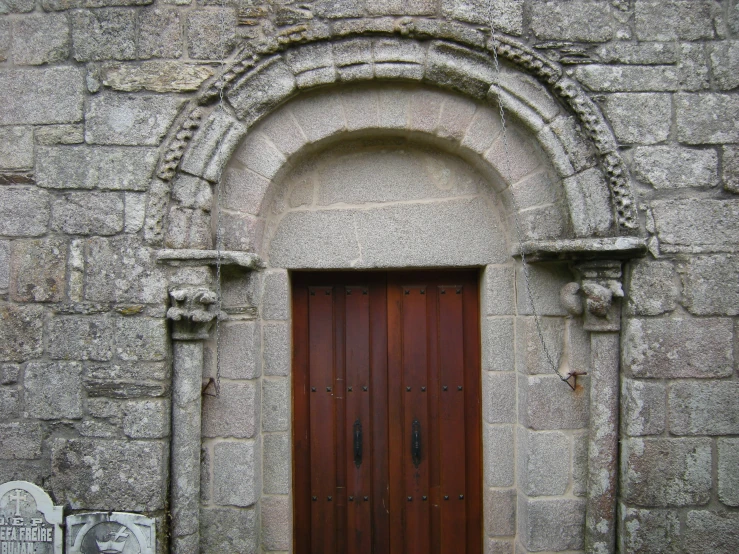 a wall is decorated with stone and arched doorways