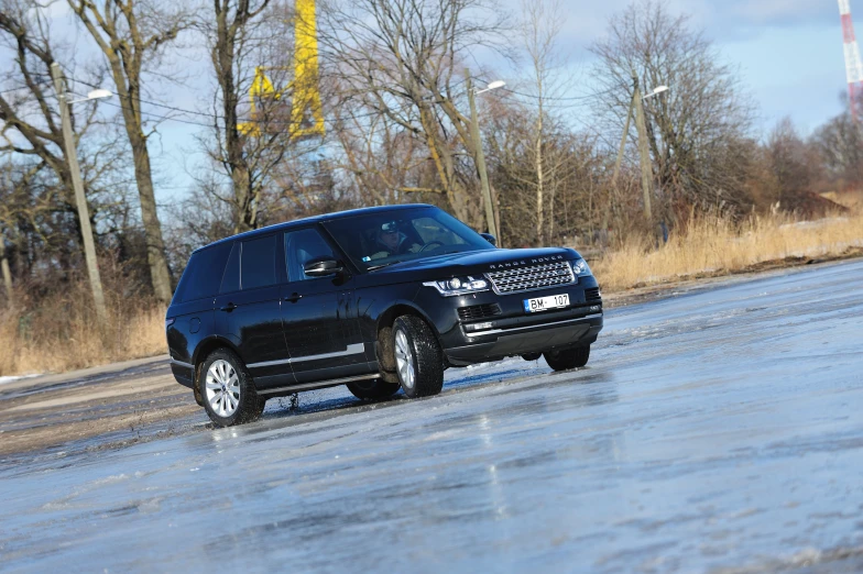 a black range rover is driving down the street