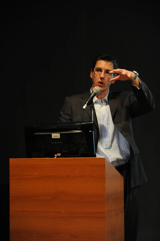 a man is pointing at soing from a podium