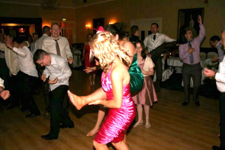 a woman in a red dress dances at a wedding