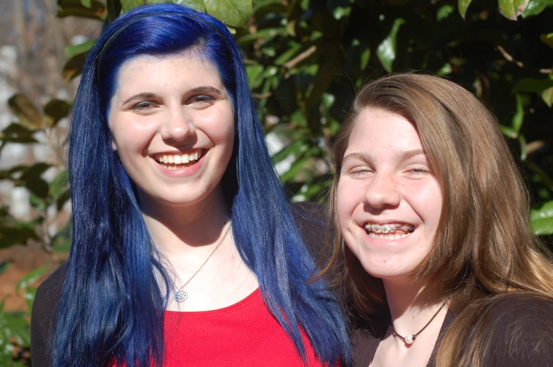 two smiling woman with blue hair next to each other