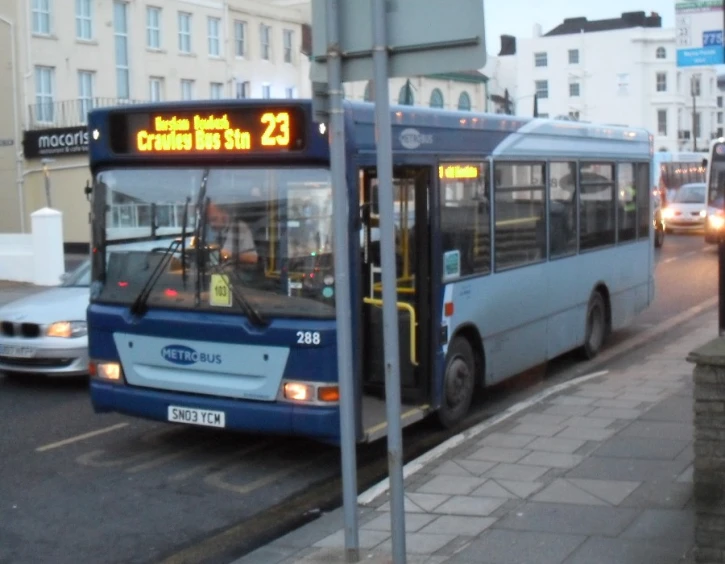 a bus is moving past a group of people on the side walk