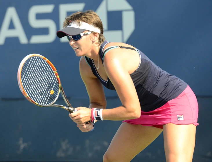 a tennis player looking down at her racket