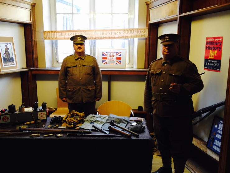 two men in uniform are standing by a table