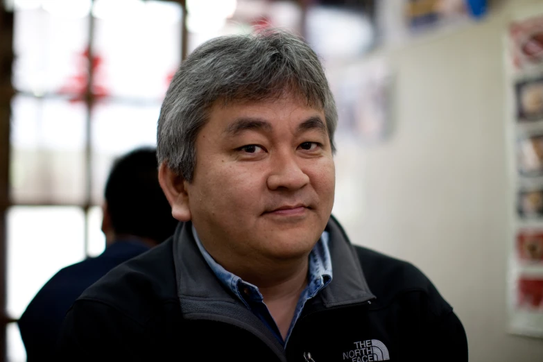 a man with gray hair in a black and grey shirt