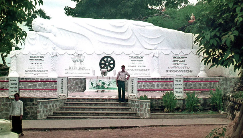 man standing in front of a white monument on display