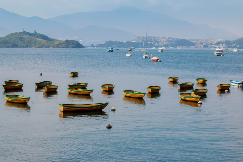 small boats floating in the water with mountains in the background