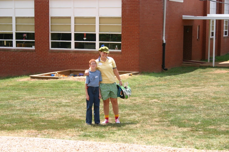 a woman and  stand in front of a school building