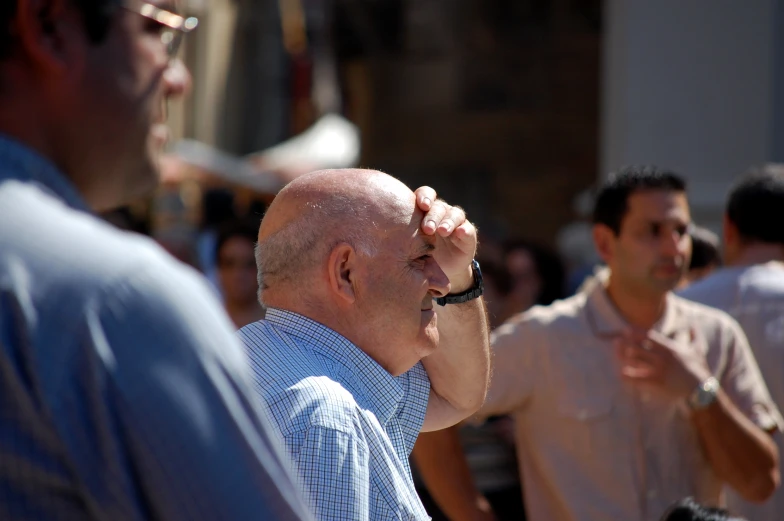 a man has his eyes closed while a man watches