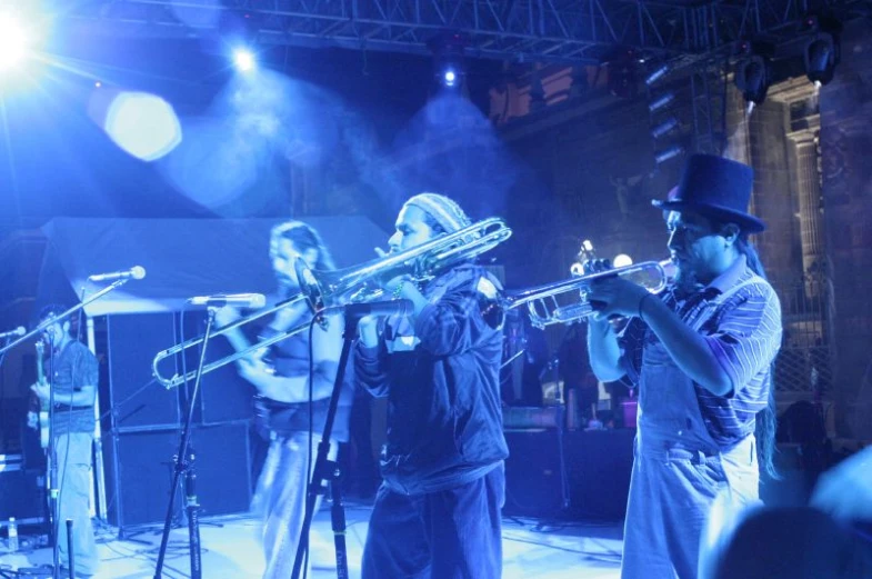 two men with hats are playing instruments on stage