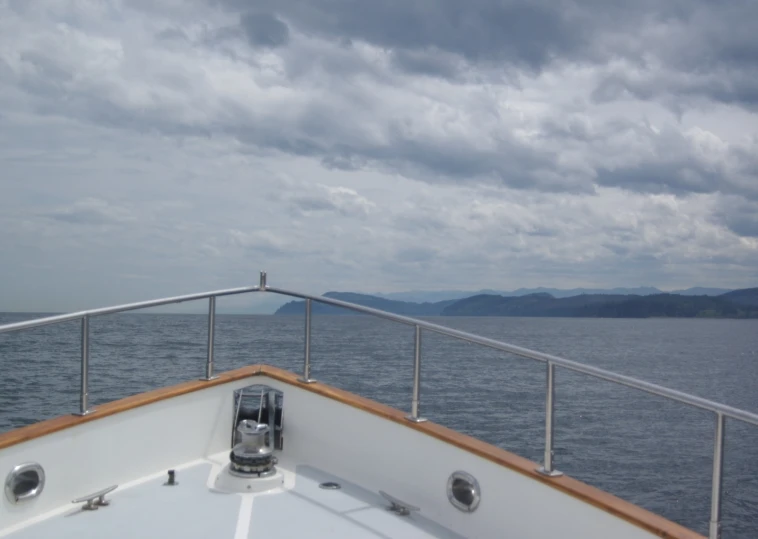 a large body of water with hills and clouds