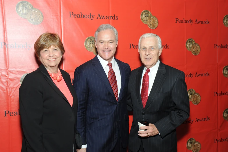 the three people are standing together on a red carpet