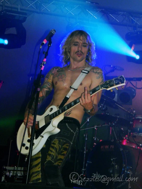 a man with long hair playing an electric guitar