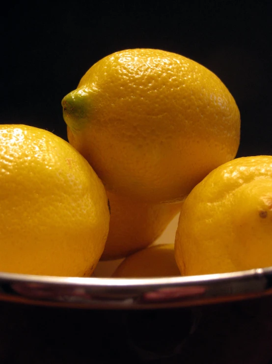 the lemons are on top of each other in a silver bowl
