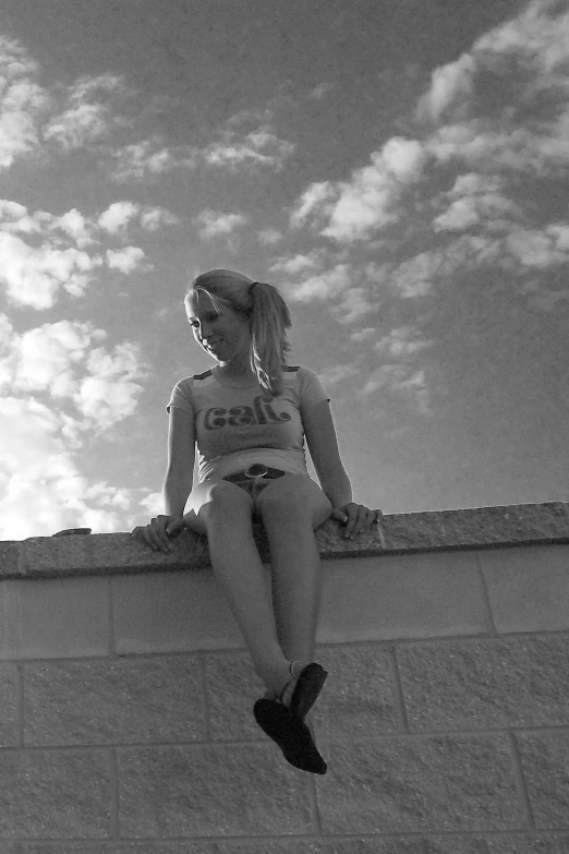 black and white pograph of a woman sitting on a ledge