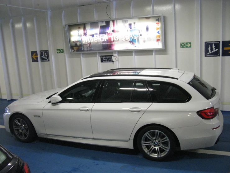 a white bmw car parked at a bus stop