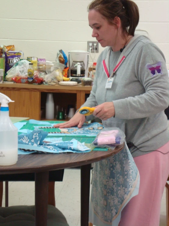 a person with an apron on with a pair of scissors