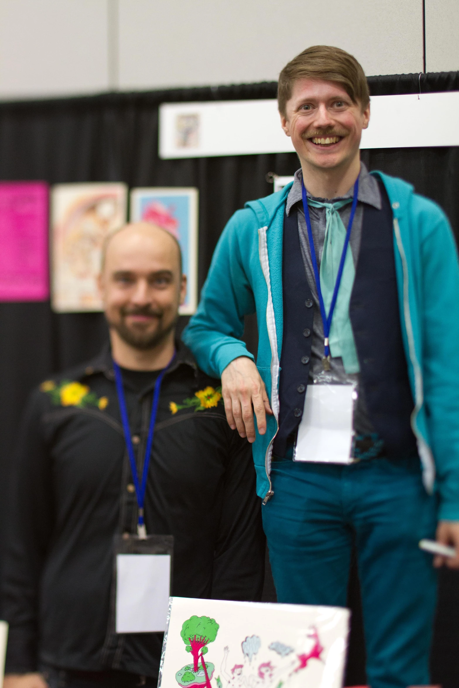 two young men are smiling in the middle of a presentation