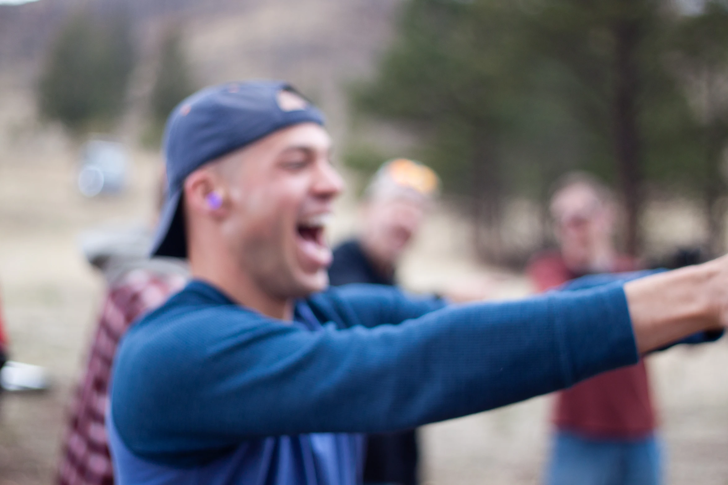 man with open hand holding a cell phone and laughing