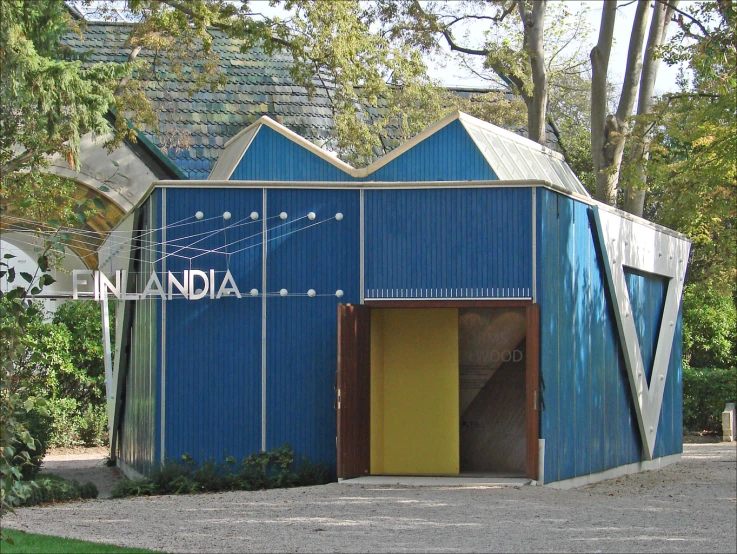 a small blue building with two doors opened