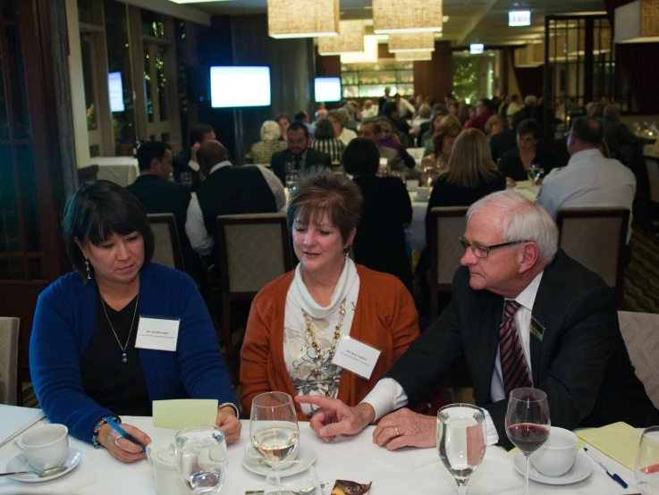 a group of people sitting at a table with food and drinks