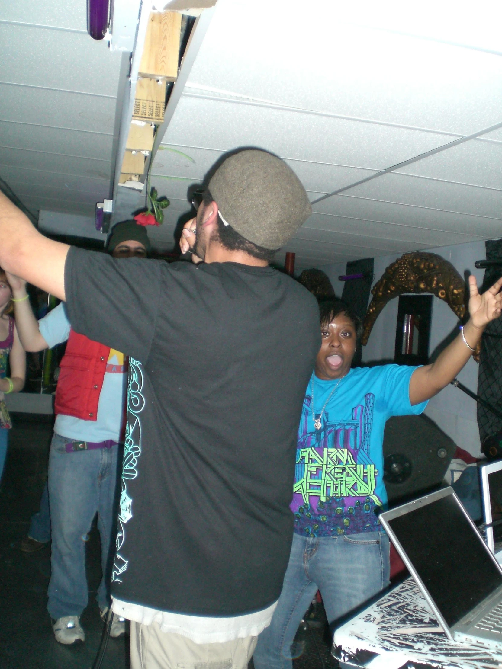 two men and two girls stand in the same room with djs