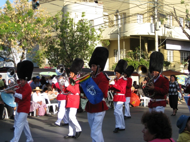 young men in uniforms playing pipes and drums on the street