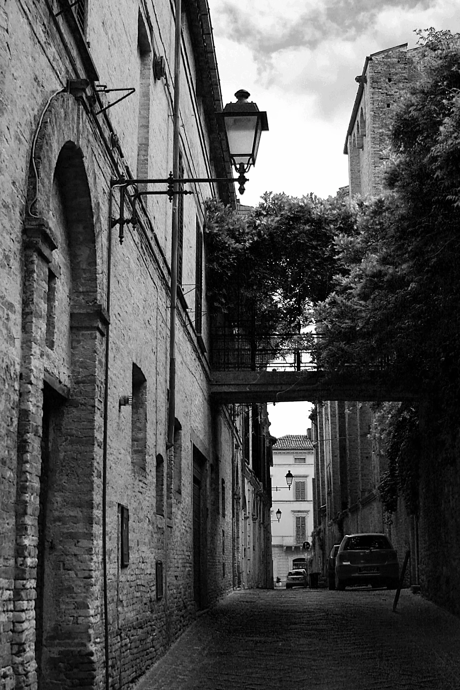 a person in a suit walking down an alleyway under some hanging lights