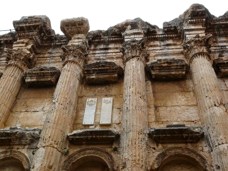 the pillars of an old building have signs on them