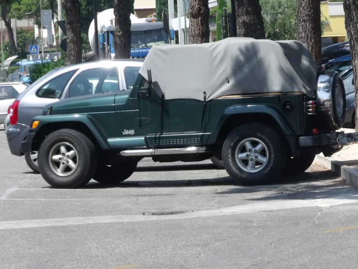 a jeep with a tent on the back parked in a parking lot