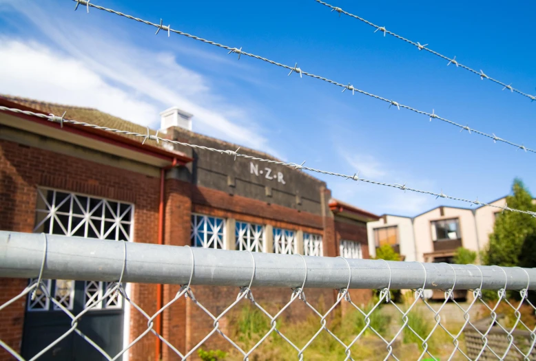 the fence is behind the buildings by the fire hydrant