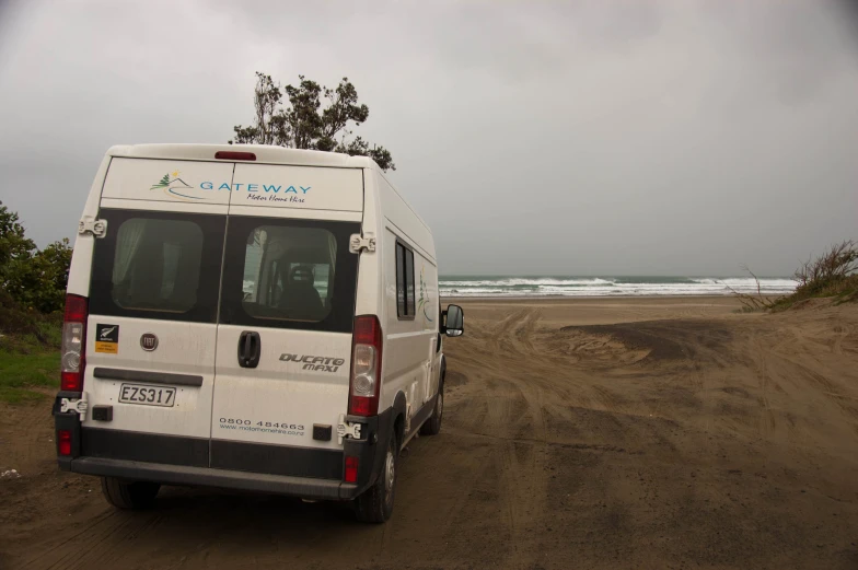 the small van is parked on the beach