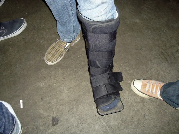 the legs and leg of a person in black leather boots standing next to one another