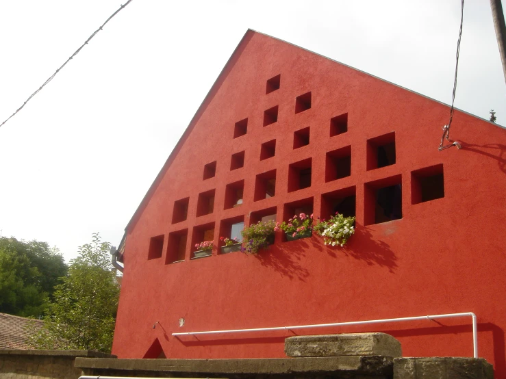 there is a red building with flowers in a window