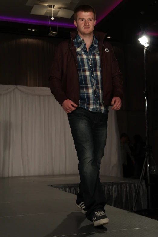 a young man on the runway looking at his cell phone