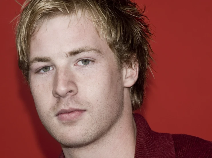 a man wearing a dark jacket and red shirt