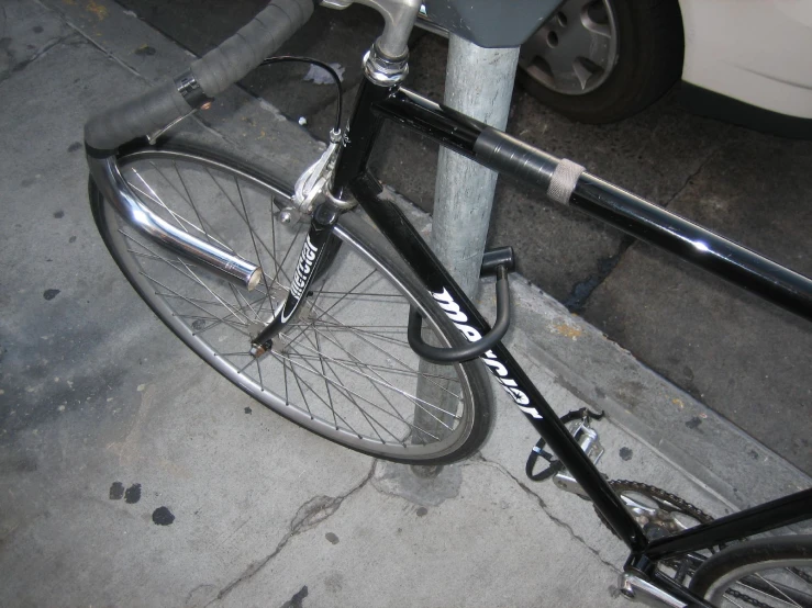 an aluminum bike is locked to a pole