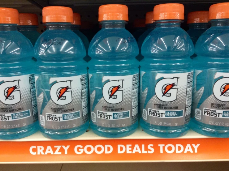 a grocery store shelf has a row of gatorade water